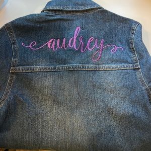 Custom embroidered denim jacket with the name “Audrey” in cursive.